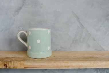 Pastel Yeşil Kupası ahşap arka plan ve çimento duvar üzerinde noktalı.