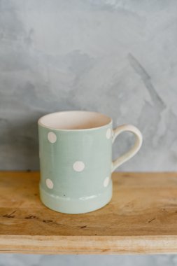 Pastel Yeşil Kupası ahşap arka plan ve çimento duvar üzerinde noktalı.