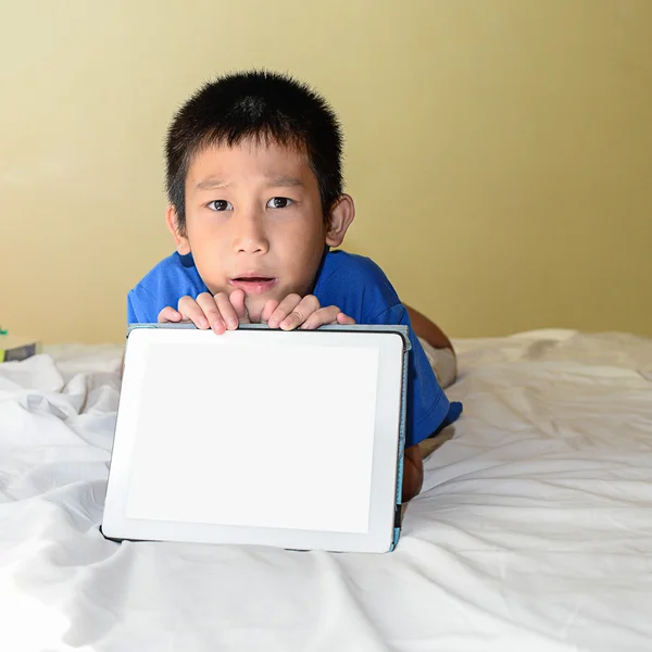 एशियाई लड़का बिस्तर पर भाई-बहन टैबलेट दिखा रहा है . — स्टॉक फ़ोटो, इमेज