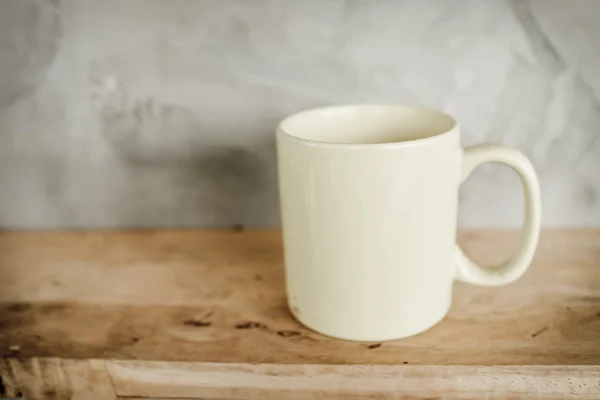 Vuile witte koffiekopje op houten plank tegen de grijze achtergrond. — Stockfoto