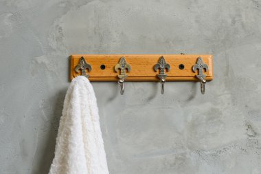 Beyaz beton duvar maruz Bathr içinde bol dökümlü havlu asılı