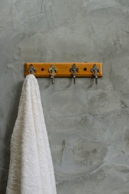 Hanging White Towel draped on Exposed Concrete Wall in the Bathr clipart