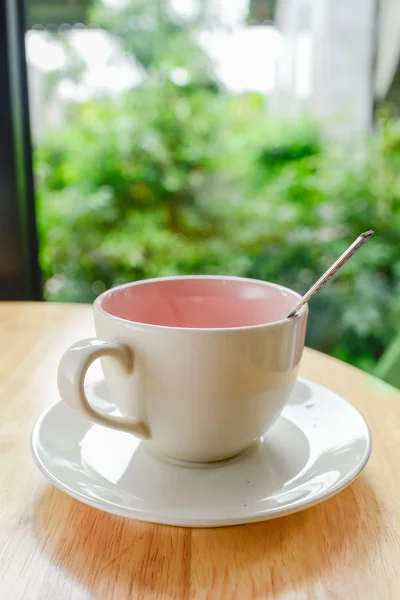 Caneca de café na mesa de madeira com fundo bokeh verde . — Fotografia de Stock