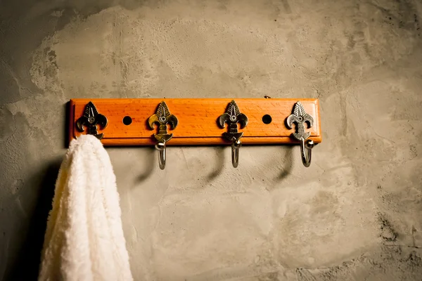 Beyaz beton duvar maruz Bathr içinde bol dökümlü havlu asılı