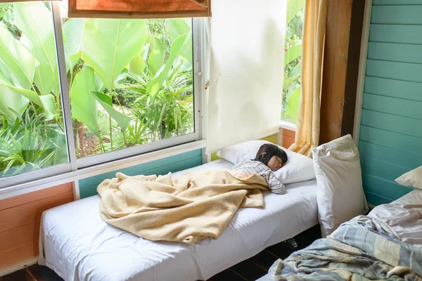 Menina asiática dormindo na cama coberta com cobertor . — Fotografia de Stock