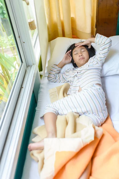 Asian girl sleeping on bed covered with blanket. — Stock Photo, Image