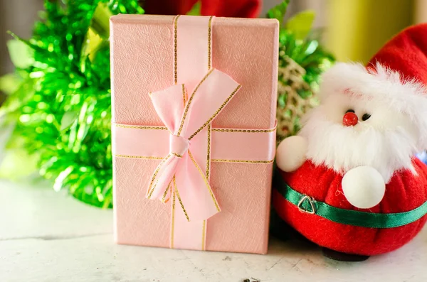 Noel baba bebek hediye kutusu ve Noel dekorasyon ahşap adam üzerinde — Stok fotoğraf