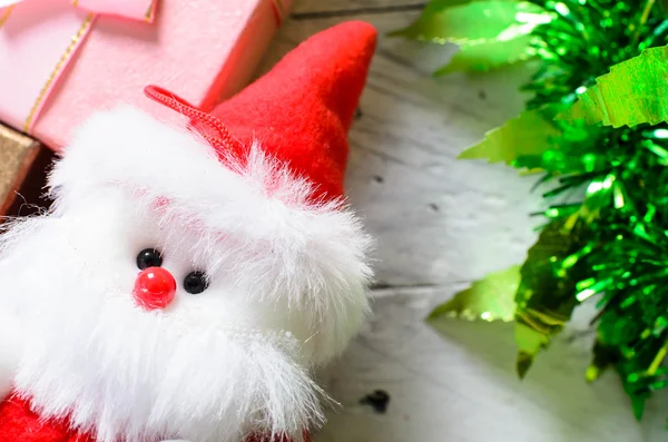 Santa doll geschenk doos en kerst decoratie op houten pagina — Stockfoto