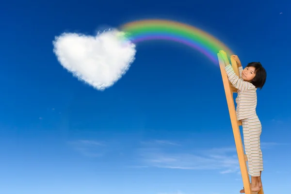 Κοριτσάκι με σκάλα πάνω από το γαλάζιο του ουρανού και καρδιά σχήμα σύννεφο, με — Φωτογραφία Αρχείου