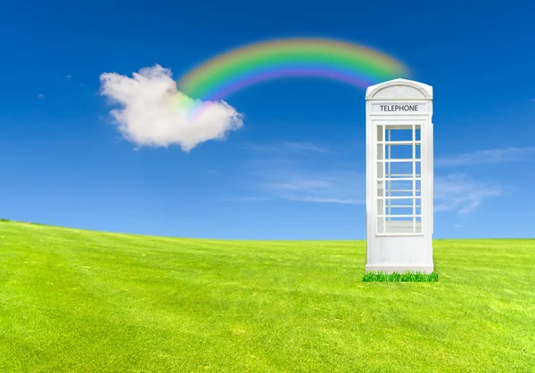 Bela paisagem com prado verde, e caixa de telefone branco — Fotografia de Stock