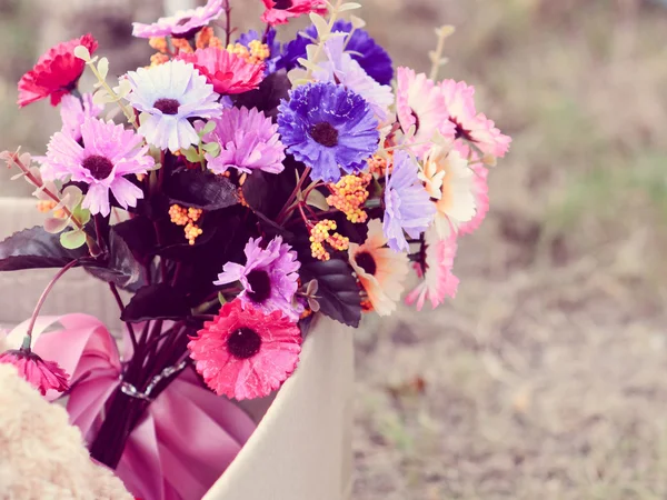 自然と緑の草の上の茶色のボックスでクマと花の花束 — ストック写真