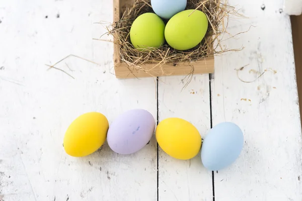 Huevos de Pascua en el nido sobre fondo de madera — Foto de Stock