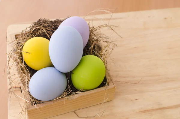 Huevos de Pascua en el nido sobre fondo de madera — Foto de Stock