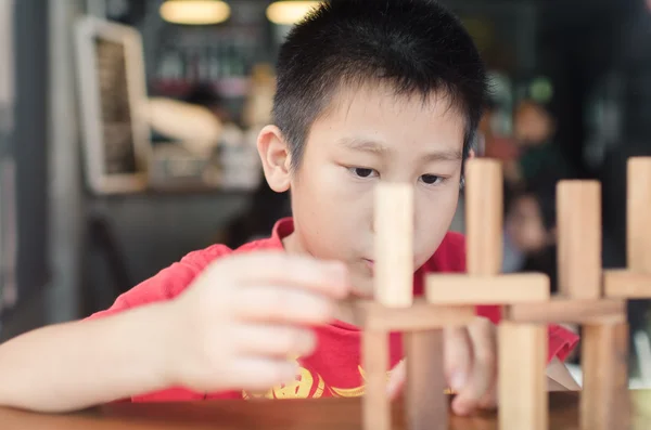 Asiatiska pojke leker med trä spelet (jenga). — Stockfoto