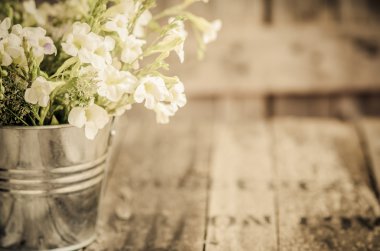 Vintage tarzı ahşap arka plan üzerinde beyaz çiçekler paslanmaz pot, 