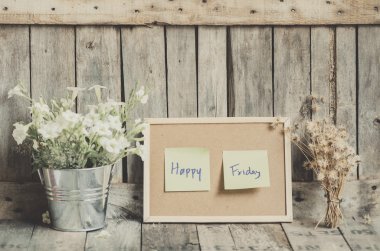 Vintage style effect Happy Friday message on corkboard with flow clipart