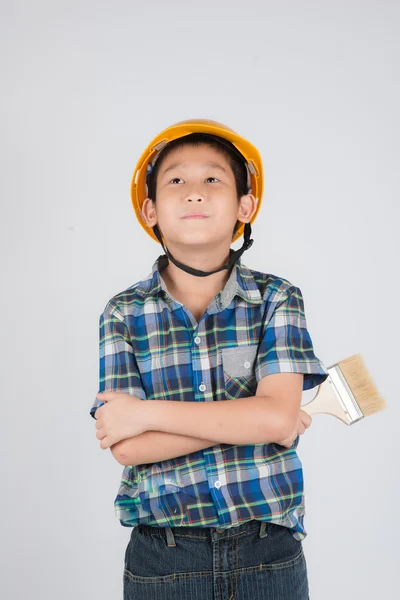 Asyalı çocuk koruyucu bir kask içinde elinde fırça ile — Stok fotoğraf