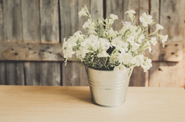 Estilo vintage Flores blancas maceta inoxidable sobre fondo de madera , — Foto de Stock