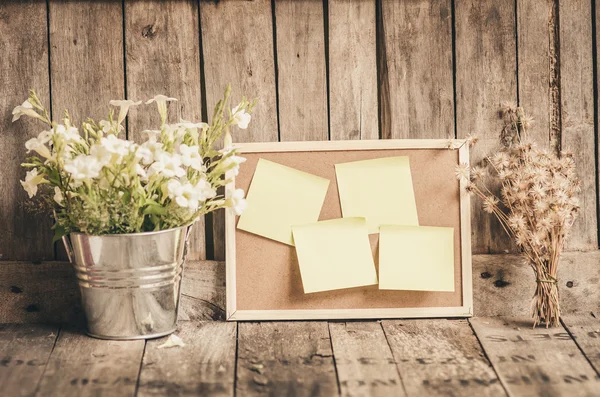 Papiers collants sur carton-liège avec pot de fleurs par fond en bois . — Photo