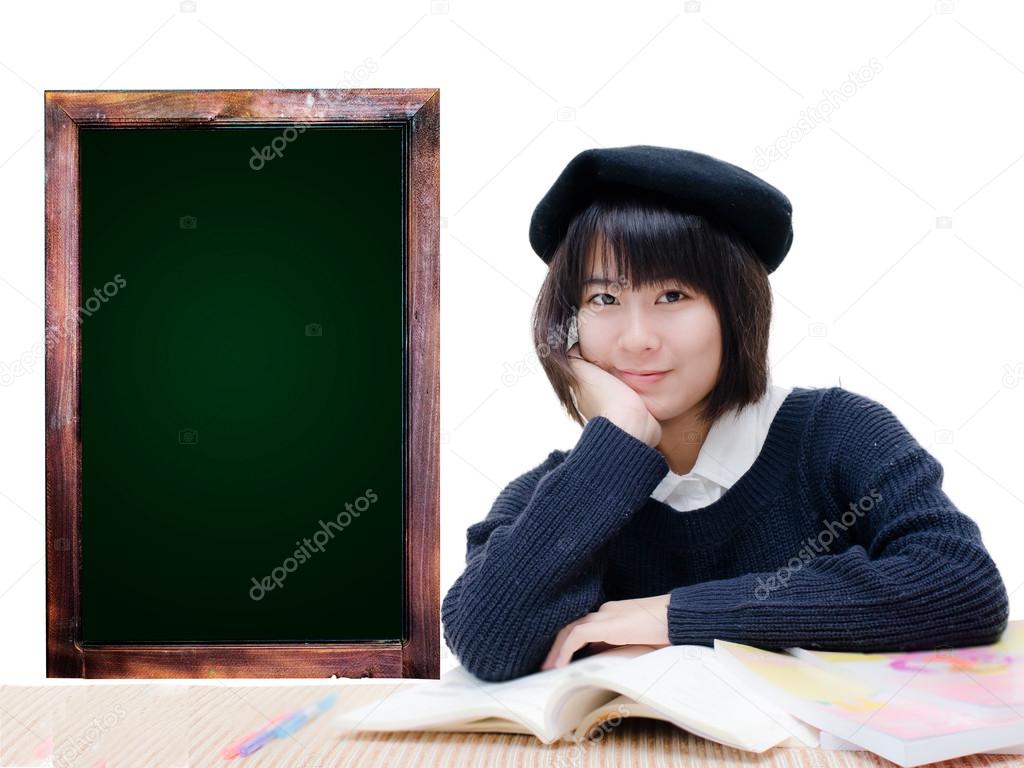 Asian teenager reading books with green board.