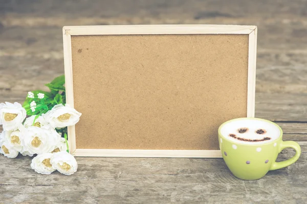 Cockboard with coffee and flower on wooden table in vintage tone — Stock Photo, Image