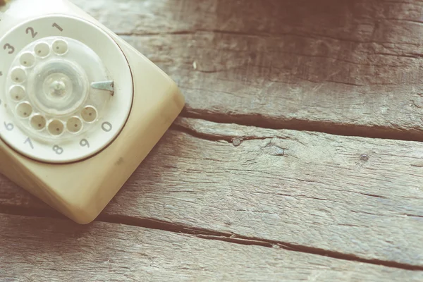 Vintage telephone on the wood desk in vintage color tone — Stock Photo, Image