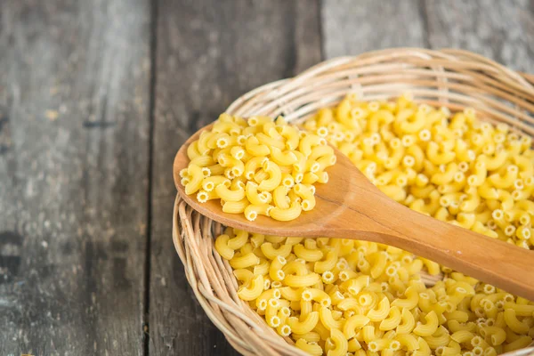 Macarrones italianos Pasta en cestería con textura de madera backgro — Foto de Stock