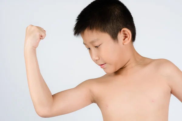 Kid visar hans muskler isolerad på grå bakgrund — Stockfoto