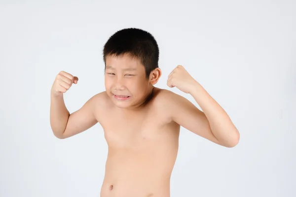 Kid visar hans muskler isolerad på grå bakgrund — Stockfoto