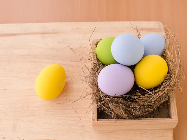 Wielkanocne jaja w gnieździe na drewniane tła — Zdjęcie stockowe