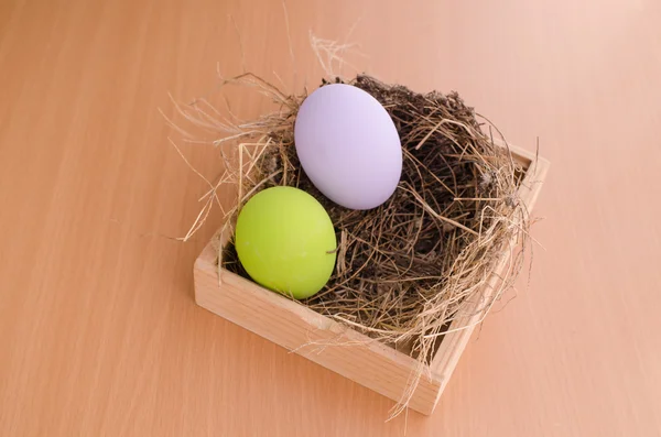 Huevos de Pascua en el nido sobre fondo de madera — Foto de Stock