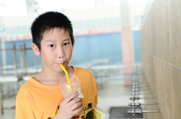 Asiatischer Junge trinkt Wasser in der Schule. — Stockfoto