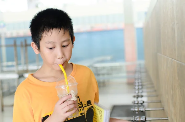 Asiatischer Junge trinkt Wasser in der Schule. — Stockfoto