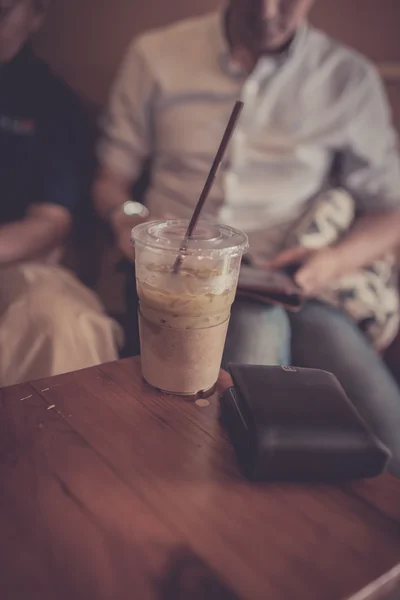 Ledová káva v plastové sklo s peněženku v kavárně s podnikatel — Stock fotografie