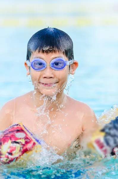 Asiático menino vestindo óculos se divertir na piscina . — Fotografia de Stock