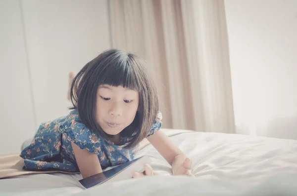 तरुण मुलगी तिच्या बेडवर लिंग आणि एक पुस्तक डब्ल्यू वाचून व्हिंटेज टोन — स्टॉक फोटो, इमेज