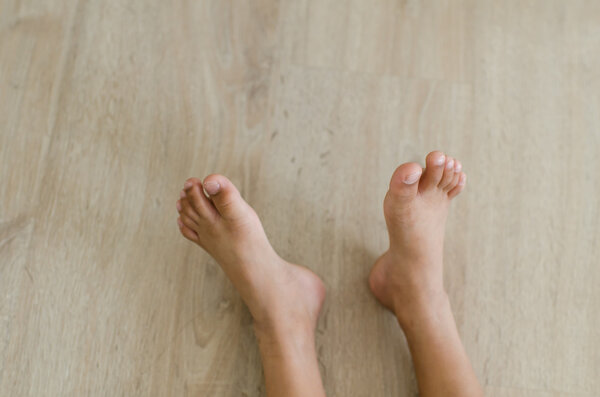 Feet of girl on wooen floor.