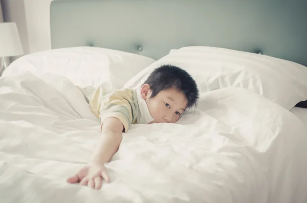 Bliska Asain chłopiec relaks na łóżku. — Zdjęcie stockowe