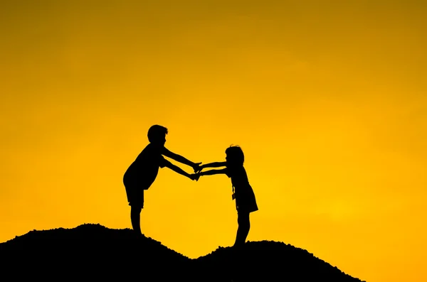 Duas crianças durante o pôr do sol, de mãos dadas . — Fotografia de Stock