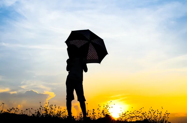 Motion blur jumping Ombrello ragazza con silhouette tramonto — Foto Stock