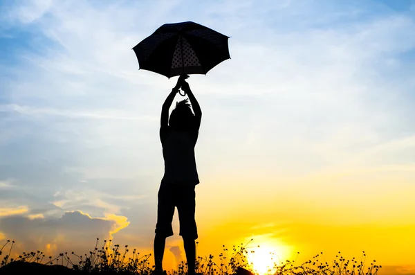 Motion blur jumping menina guarda-chuva com silhueta de pôr do sol — Fotografia de Stock