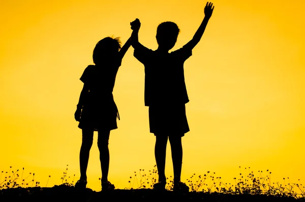 Silueta de hermano pequeño y hermana — Foto de Stock