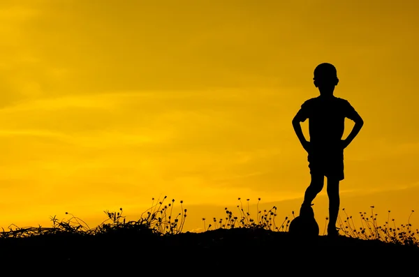 Silhueta de menino jogando bola com pôr do sol . — Fotografia de Stock