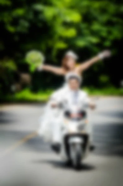 Verschwommener Hintergrund, gerade verheiratet. Bräutigam und Braut auf dem Motorrad — Stockfoto