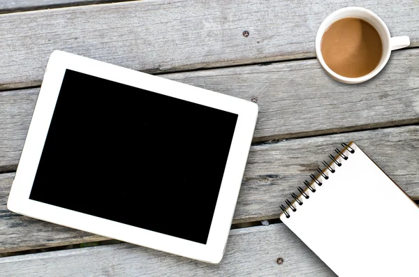Tablet xícara de café e notebook sobre fundo de madeira . — Fotografia de Stock
