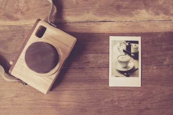 Macchina fotografica giocattolo vintage e stampa polaroid su tavolo in legno . — Foto Stock