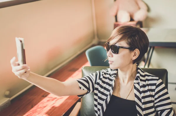 Hermosa mujer hipster pelo corto inteligente con gafas de sol en th — Foto de Stock