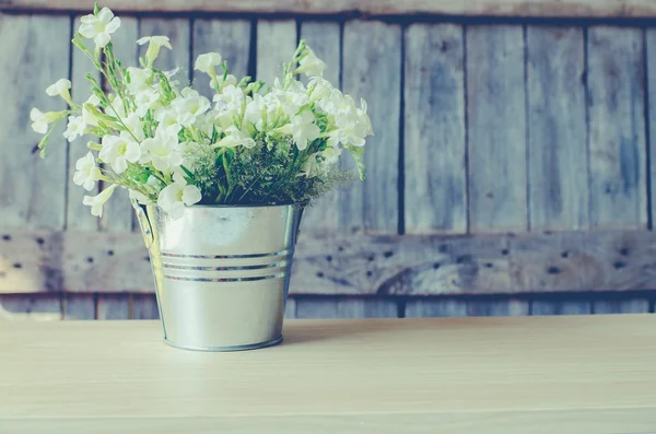 Vintage flower rostfri gryta med trä bakgrund. — Stockfoto