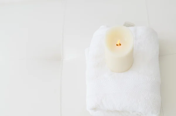Świeca na biały ręcznik — Zdjęcie stockowe