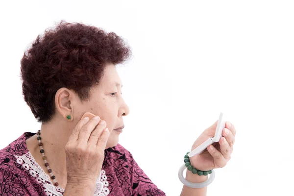 Senior woman doing a make-up — Stock Photo, Image